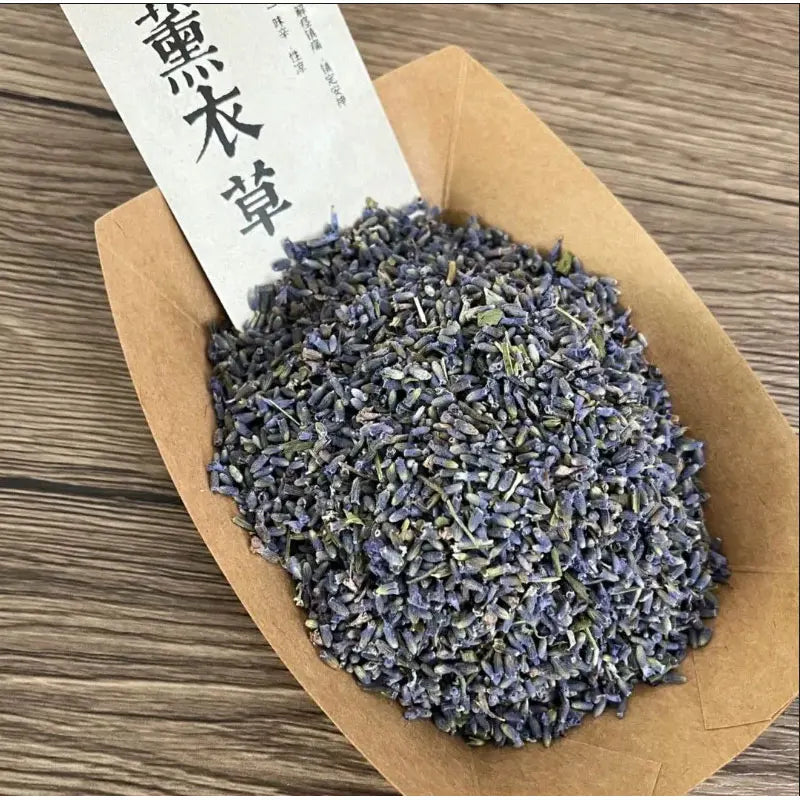 Tas de fleurs de lavande séchée en vrac dans une barquette en papier kraft, étiquette chinoise, sur fond bois - Nesty