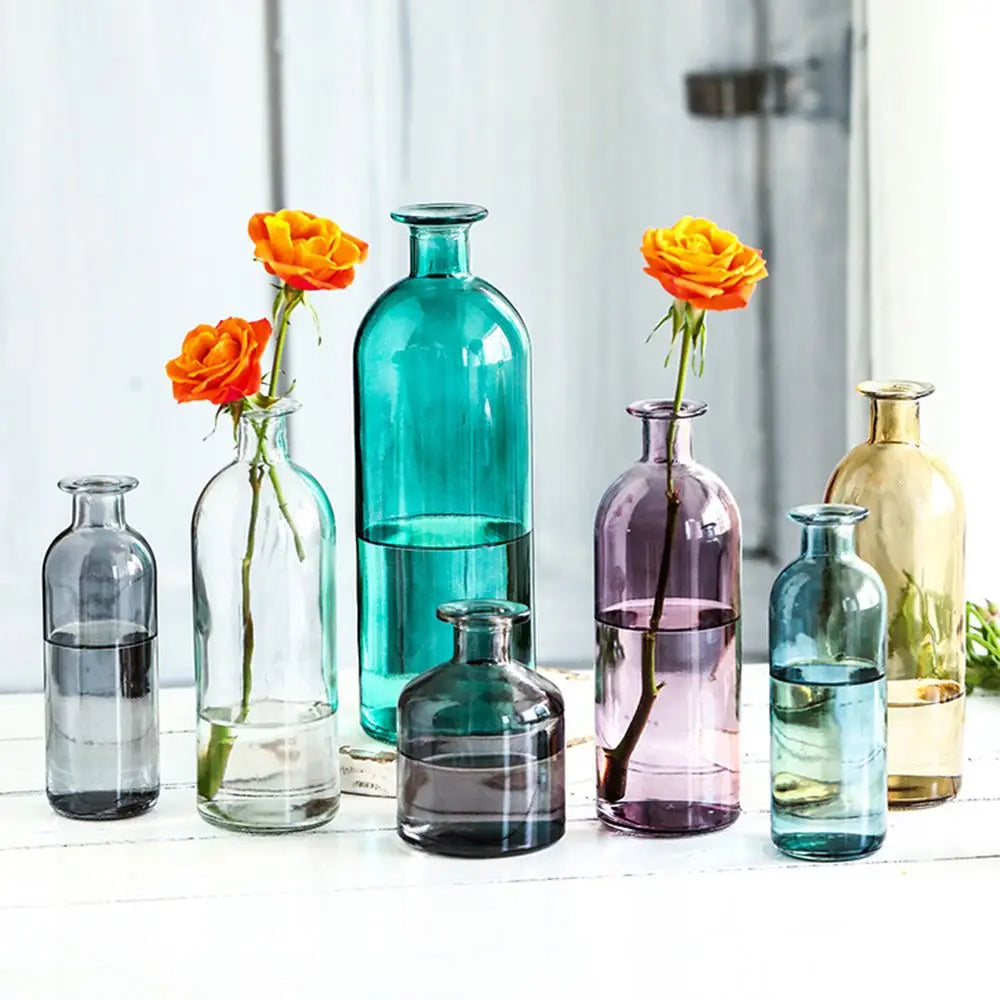 Vase en verre pour bouture hydroponique Nesty - Sept coloris avec roses oranges, sur étagère en bois blanc