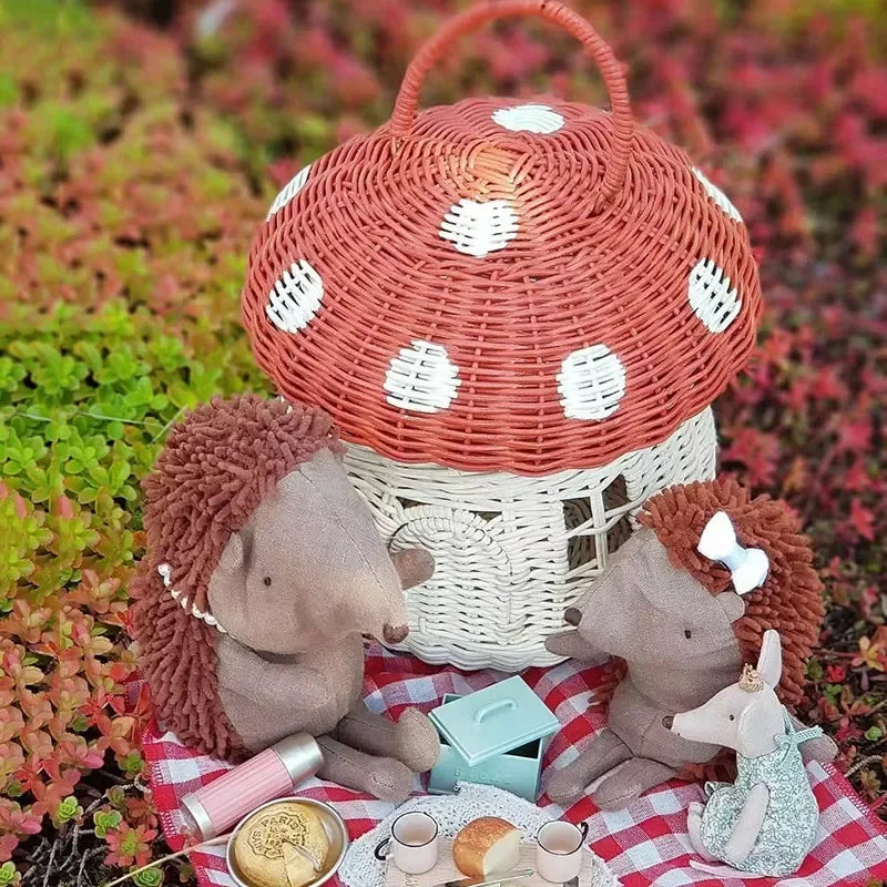 Petit panier tressé en osier forme champignon, panier décoratif Nesty, coloris rouge à pois blancs posé en extérieur avec des peluches hérissons en pique-nique