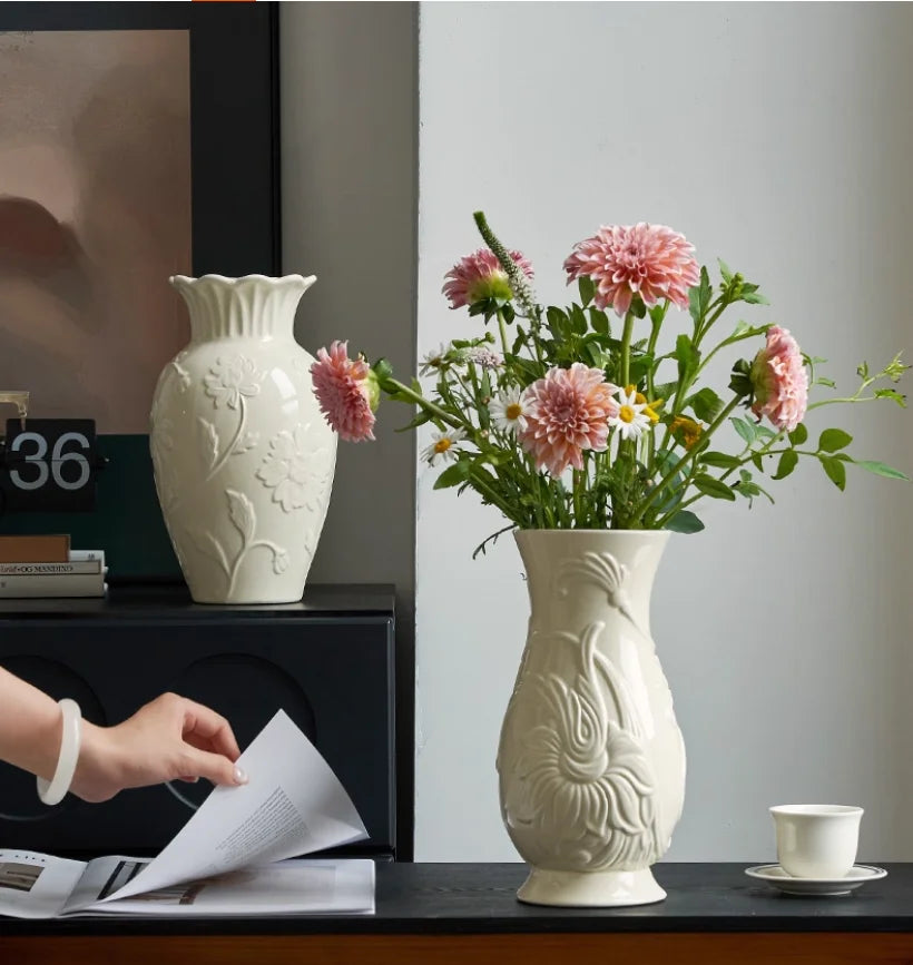 Vase en céramique crème à relief, style intemporel Nesty, deux vases à relief floral, l'un sur un meuble noir, l'autre garni de fleurs roses et blanches