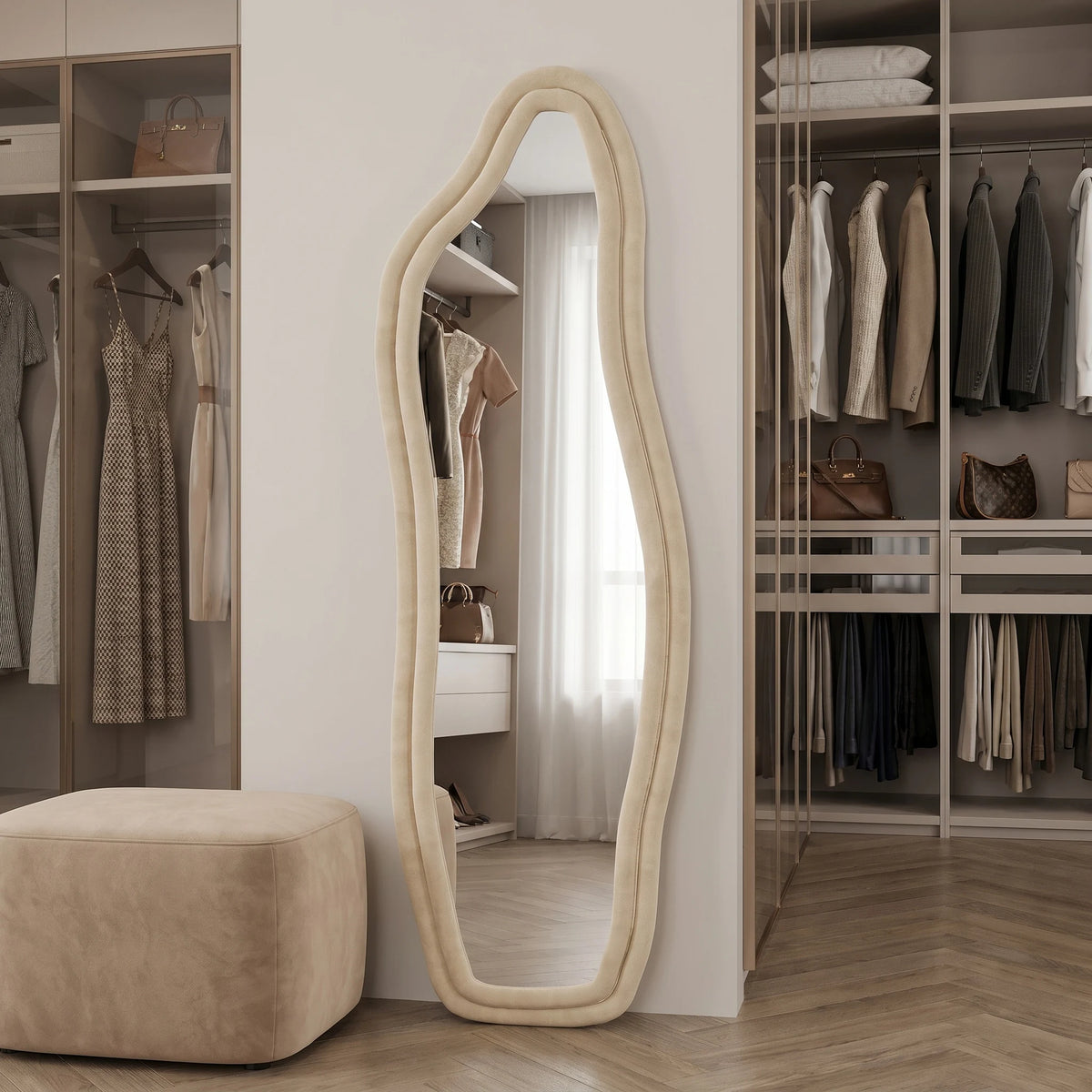 Grand miroir sur pied forme organique ondulée, cadre velours beige, dans un dressing avec sacs à main et vêtements suspendus - Nesty