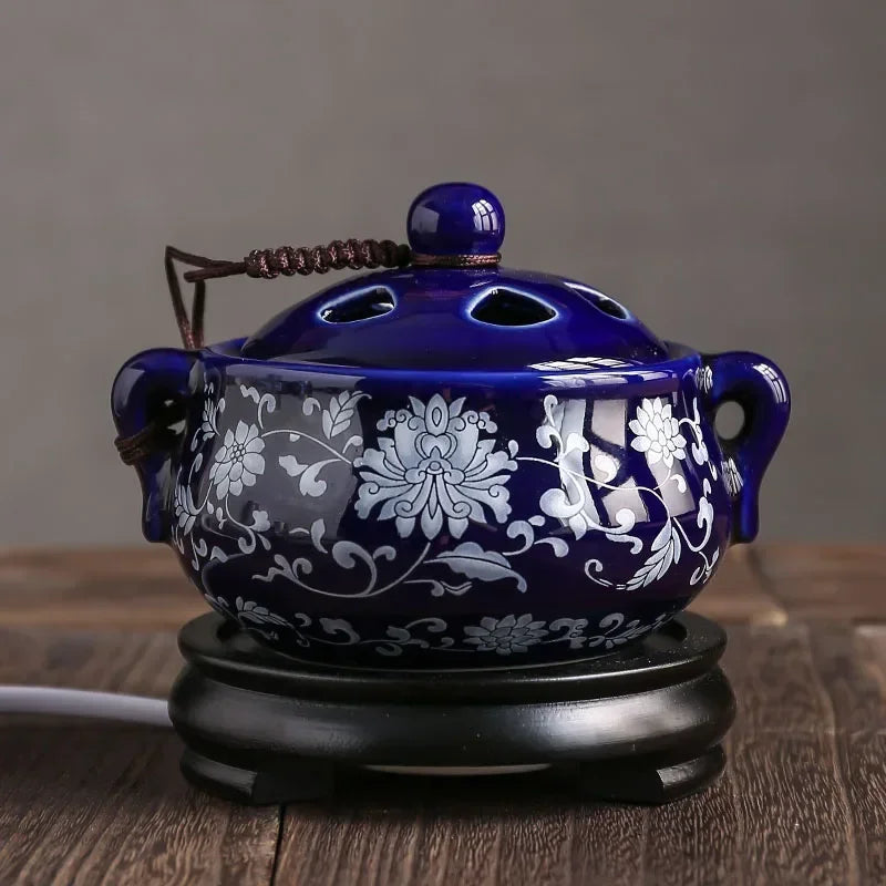 Brûle-encens électrique en céramique Nesty - Modèle bleu motif floral blanc avec anses, posé sur socle en bois
