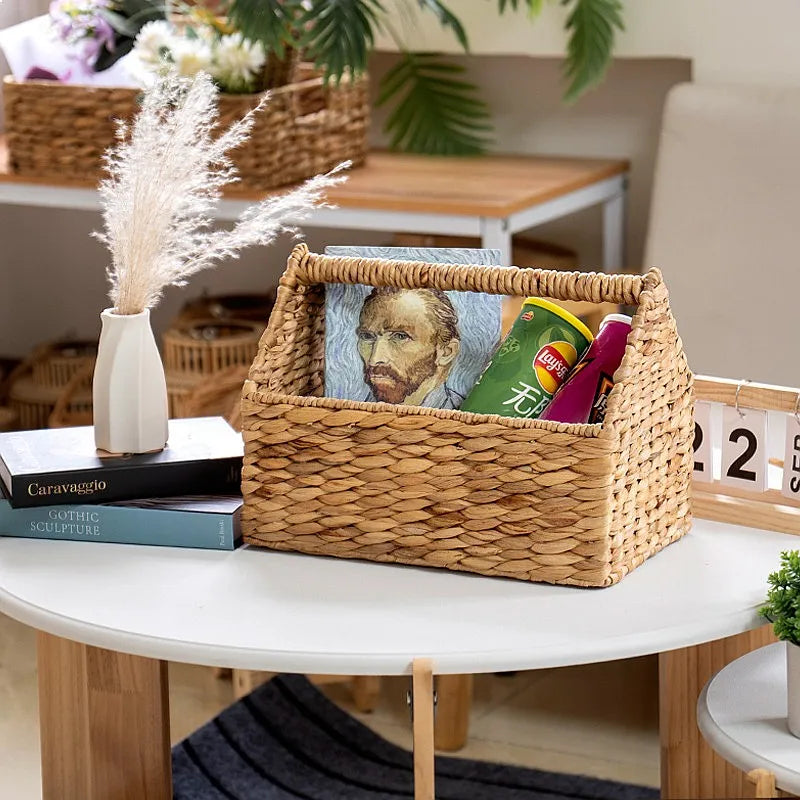 Panier de rangement suspendu en corde tressée Nesty, panier garni d'un livre et de paquets de chips, sur table blanche