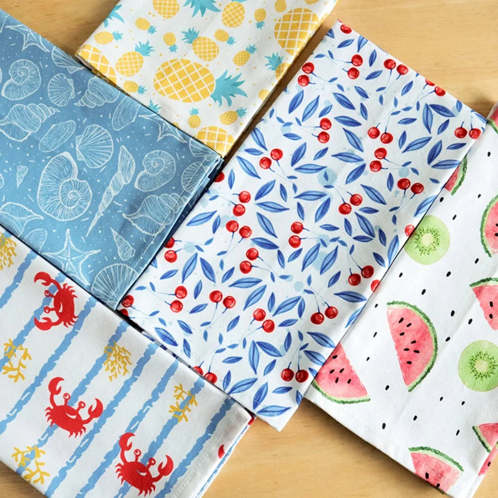 Cinq torchons en coton pliés aux motifs été : coquillages bleus, ananas jaunes, cerises et feuillage bleu, crabes rayés, pastèque et kiwi - Nesty