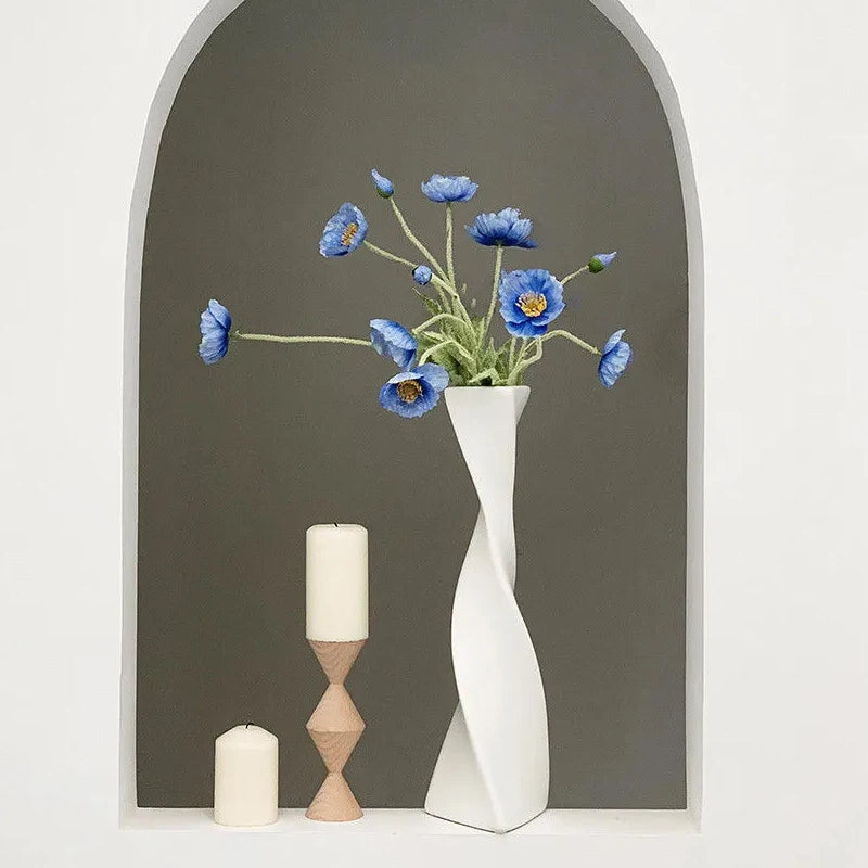 Vase céramique haut et torsadé Nesty - Coloris blanc avec fleurs de pavot bleues, dans une niche en arche avec bougies