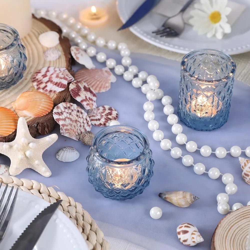 Photophores en verre à motif losange Nesty - Version bleue sur table marine avec coquillages et collier de perles