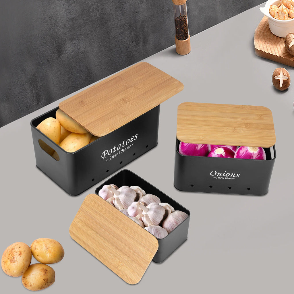 Set de 3 boîtes de rangement ventilées, couvercles en bambou Nesty, coloris noir, boîtes Potatoes, Onions et Garlic ouvertes garnies, sur plan de travail gris et marbre