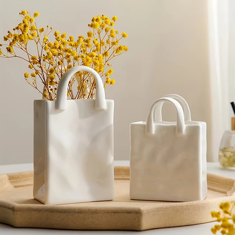 Mini vase blanc forme sac à main, fleurs séchées - Nesty - Deux tailles avec fleurs séchées jaunes, sur un plateau en bois, verre et bougie en arrière-plan