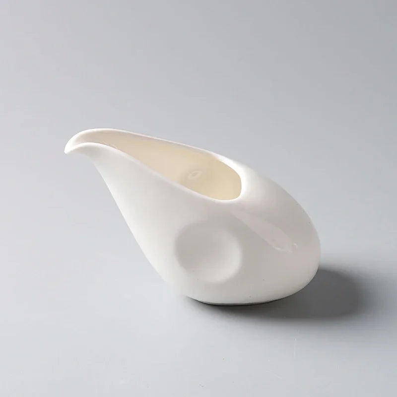 Petit pot à lait en céramique blanche avec anse Nesty, gros plan en angle sur un pot, vue de trois-quarts