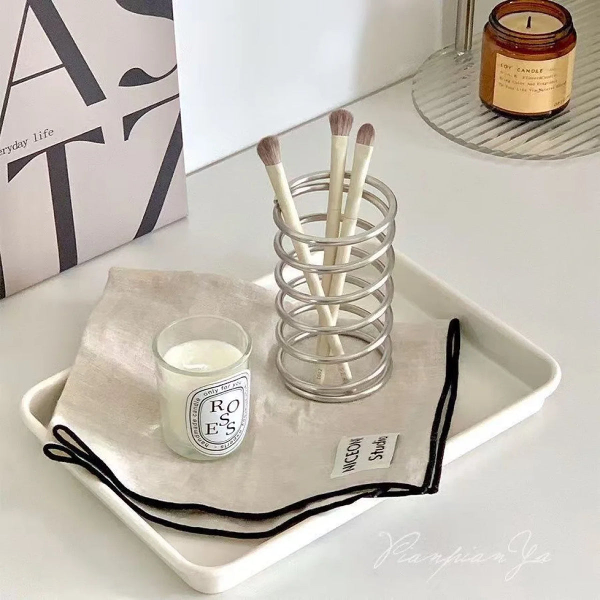 Porte-brosses à dents en inox Nesty - Utilisé avec une bougie et une pochette sur un plateau