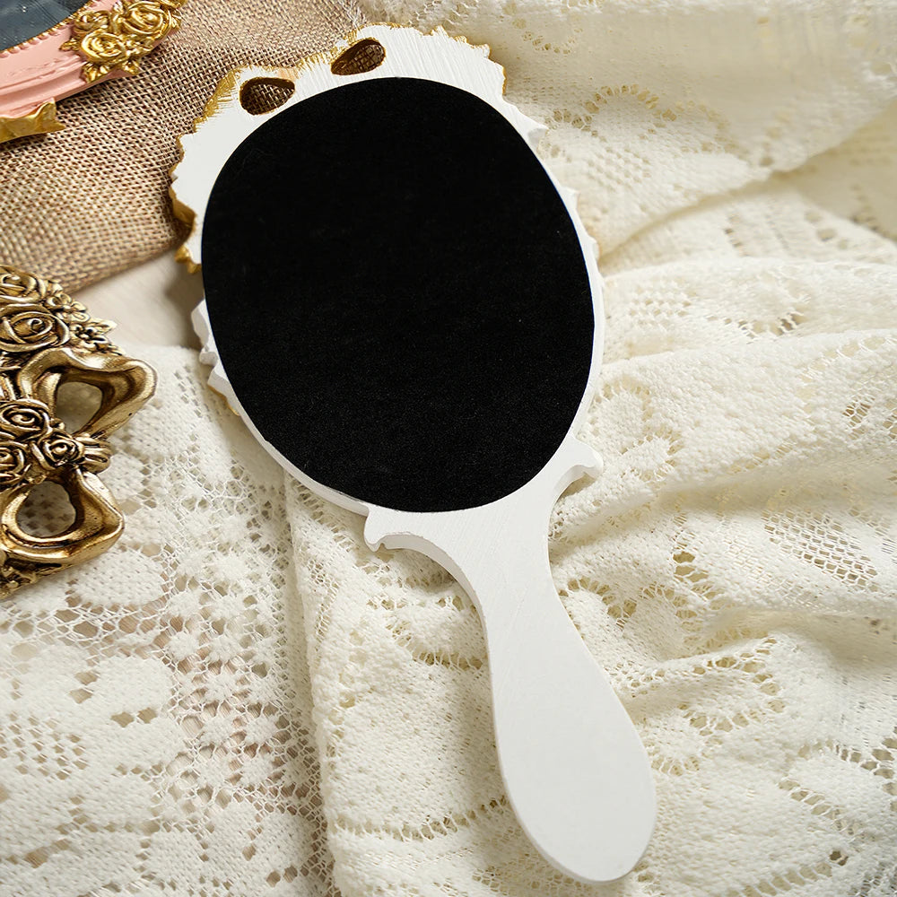 Miroir à main baroque Nesty - Dos du modèle blanc en velours noir, posé sur dentelle