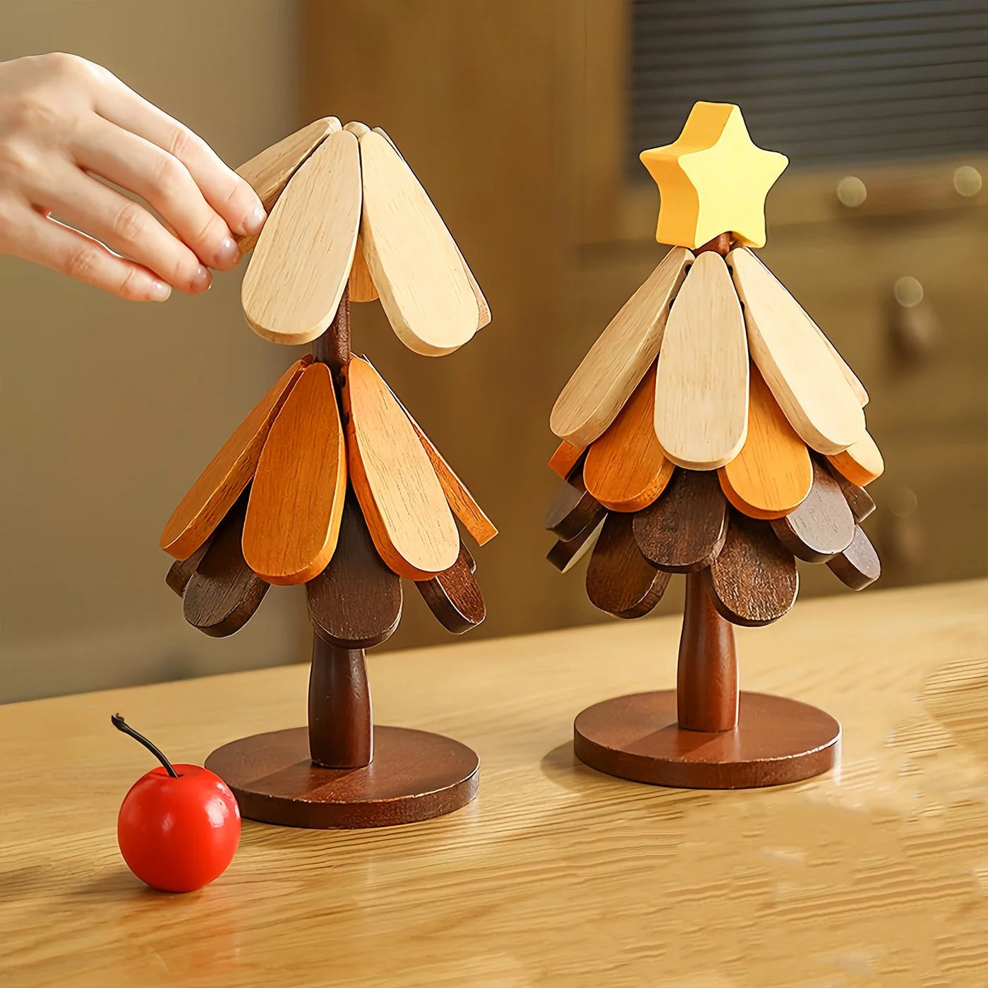 Deux figurines sapin de Noël en bois pliable, une main dépliant les pétales du haut, décoration étoile et cerise - Nesty