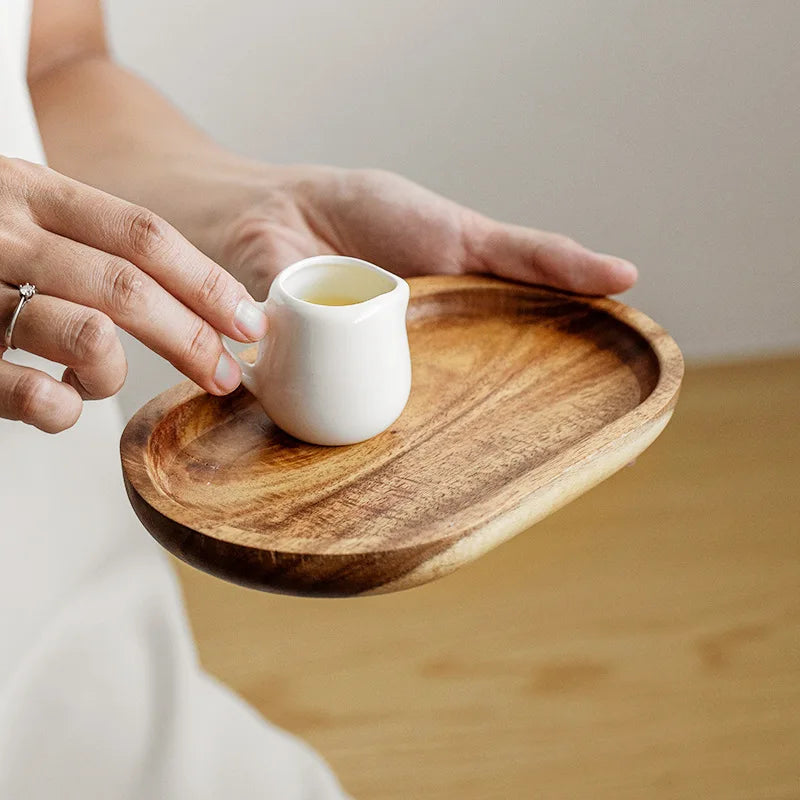 Plateau en bois de noyer, modèle japonais Nesty, plateau ovale tenu à la main avec un petit pot en céramique blanc contenant du thé