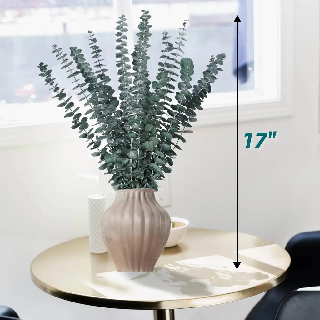 Branches d'eucalyptus séché dans un vase côtelé rose poudré, hauteur 17 pouces (43 cm), posé sur une table ronde dorée - Nesty
