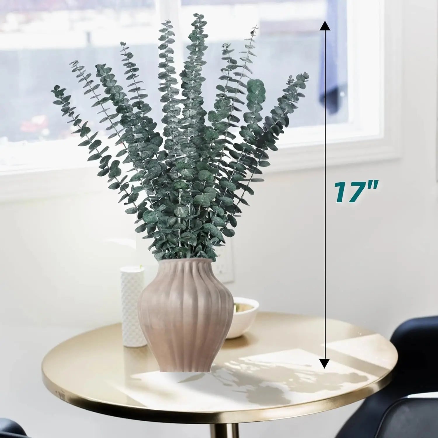 Branches d'eucalyptus séché dans un vase côtelé rose poudré, hauteur 17 pouces (43 cm), posé sur une table ronde dorée - Nesty