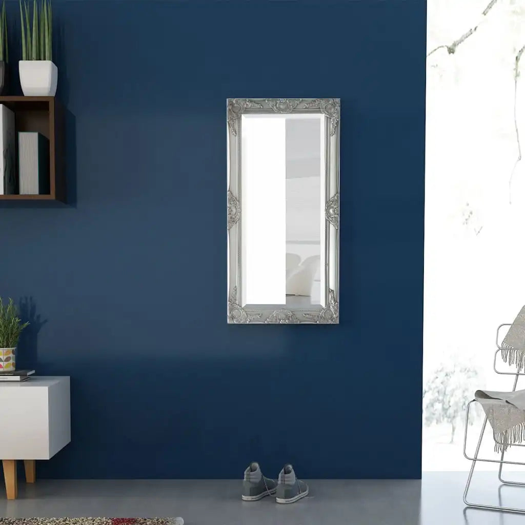 Miroir mural baroque Nesty - Accroché à la verticale sur un mur bleu marine, au-dessus d'une console blanche