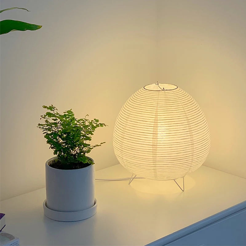 Lampe de table nordique Nesty - Allumée sur une étagère près d'une plante
