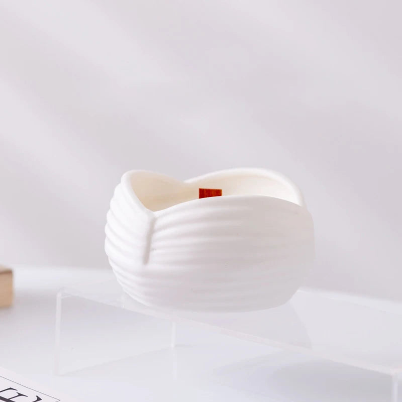 Photophore céramique côtelé forme vagues, mèche en bois de bougie DIY visible, posé sur un support transparent - Nesty