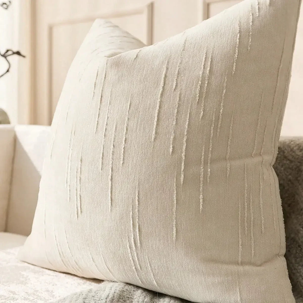 Housse de coussin en lin imitation, beige, motif géométrique bohème Nesty, gros plan sur la texture beige à fines rayures verticales brossées d'une housse de coussin carrée, posée sur canapé