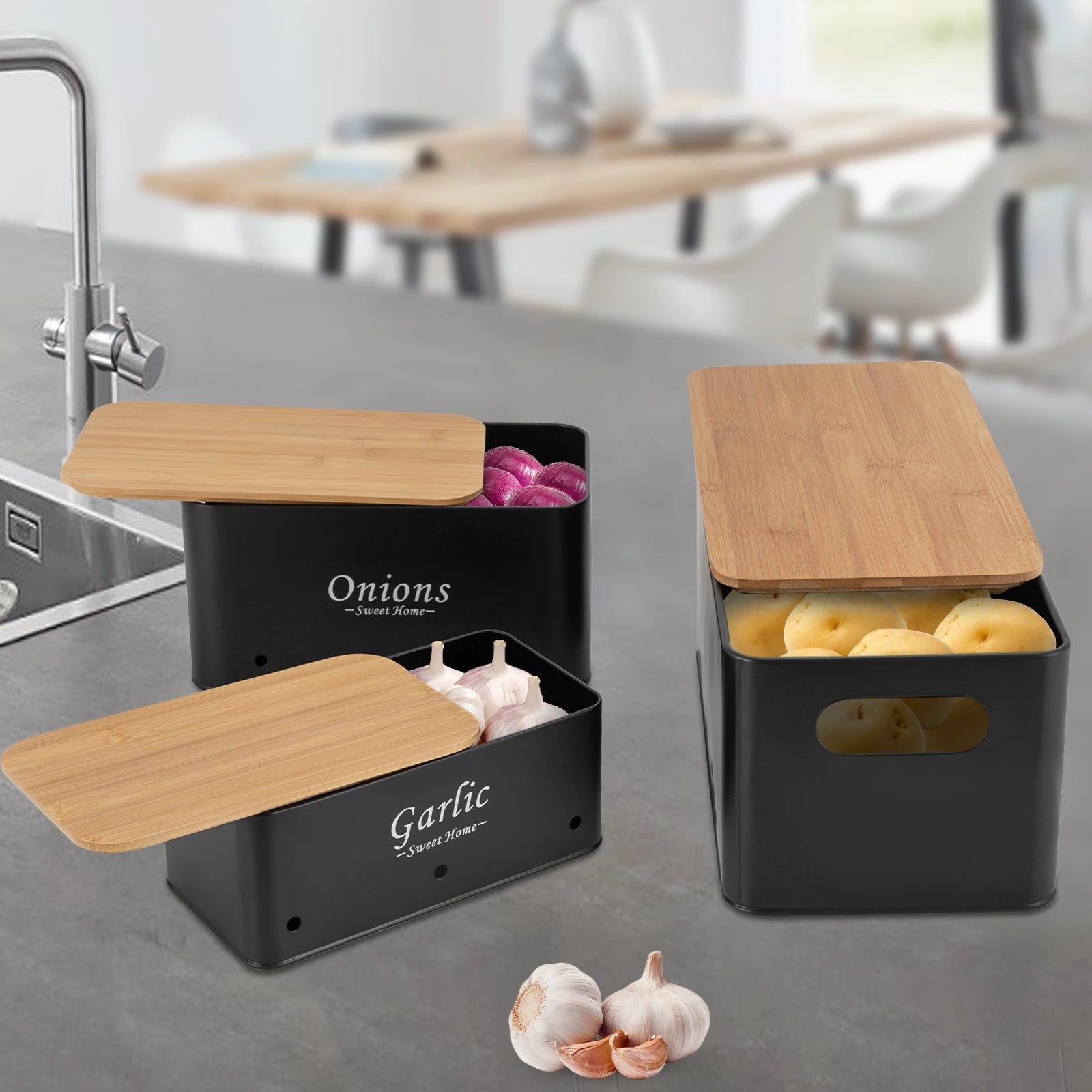 Set de 3 boîtes de rangement ventilées, couvercles en bambou Nesty, coloris noir, boîtes Onions et Garlic ouvertes garnies d'oignons rouges et d'ail, boîte Potatoes garnie de pommes de terre, sur plan de travail cuisine