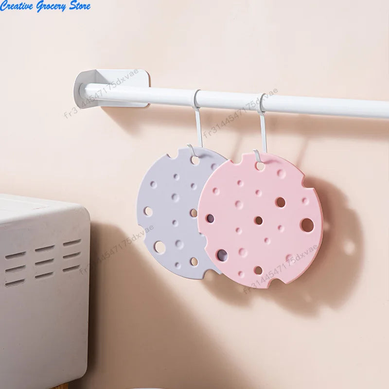 Duo de dessous de plat en silicone forme fromage, coloris gris et rose, suspendus à une barre murale - Nesty