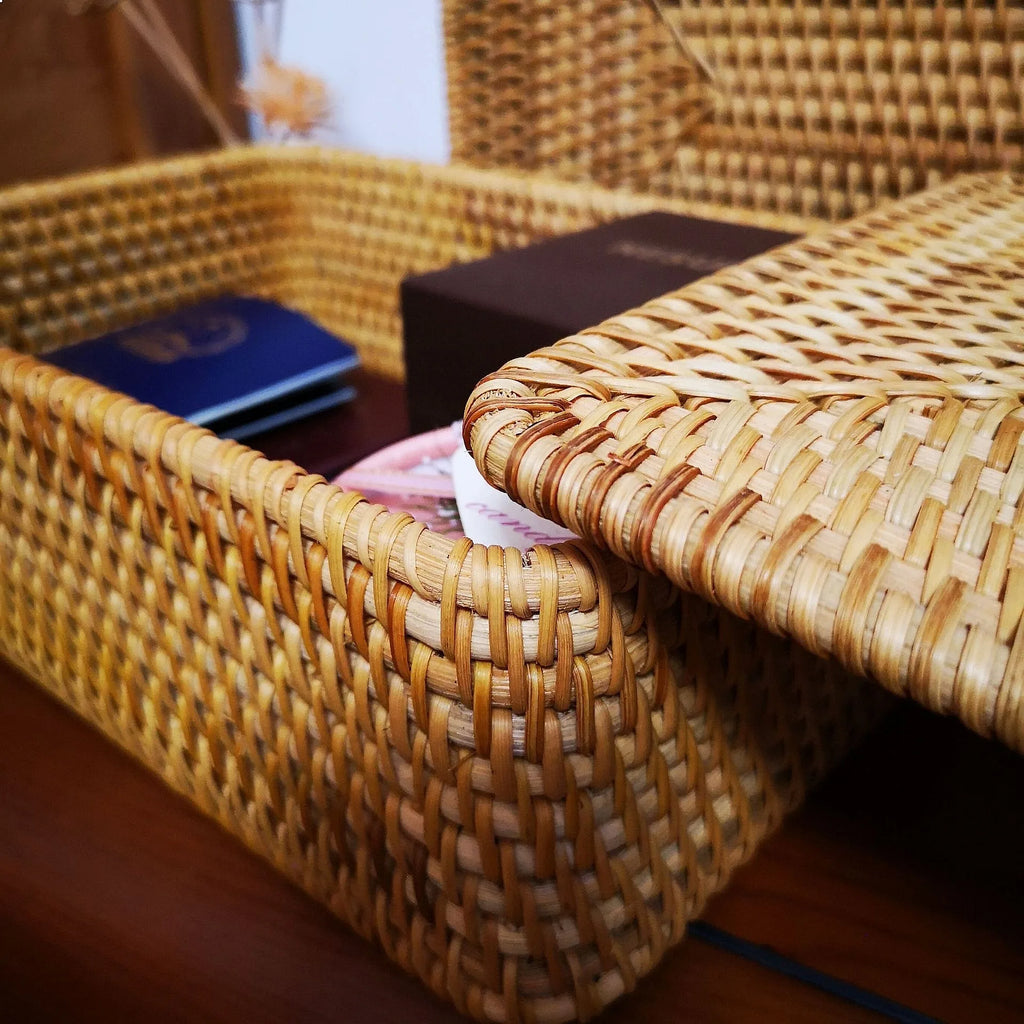 Boîte de rangement carrée en rotin tressé avec couvercle Nesty, gros plan sur le tressage du coin, passeport bleu et écrin marron visibles à l'intérieur