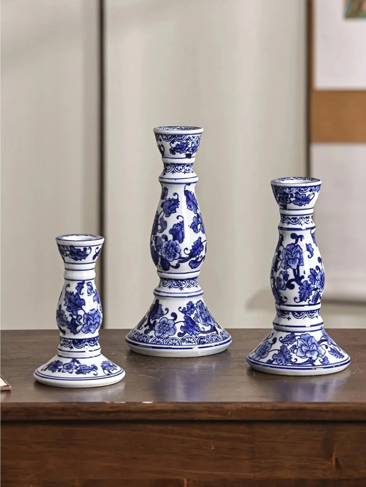 Bougeoir en porcelaine bleue et blanche Nesty - Trois bougeoirs à motifs floraux bleus de tailles différentes, alignés sur un meuble