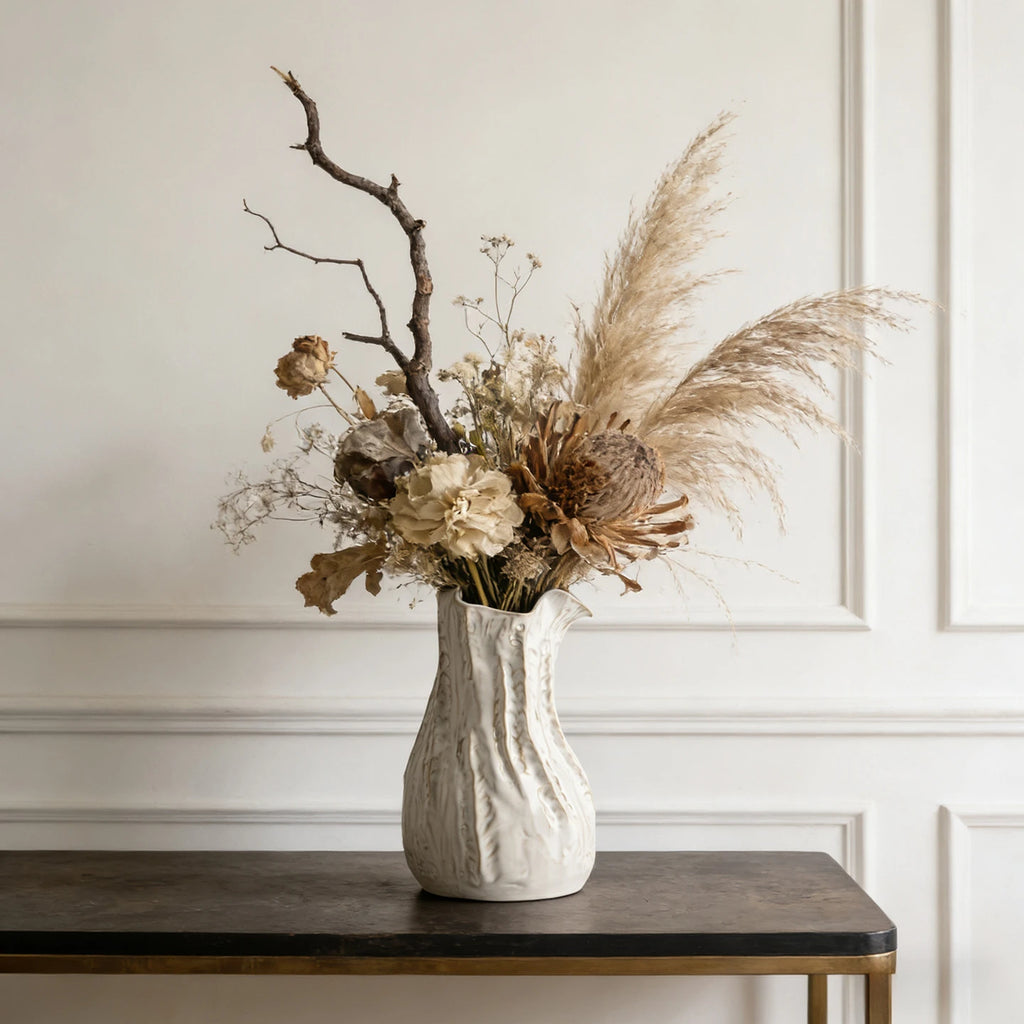 Vase en céramique texturiée blanc crème, esprit wabi-sabi japandi Nesty, garni d'herbes de pampa et de roses séchées, sur table sombre