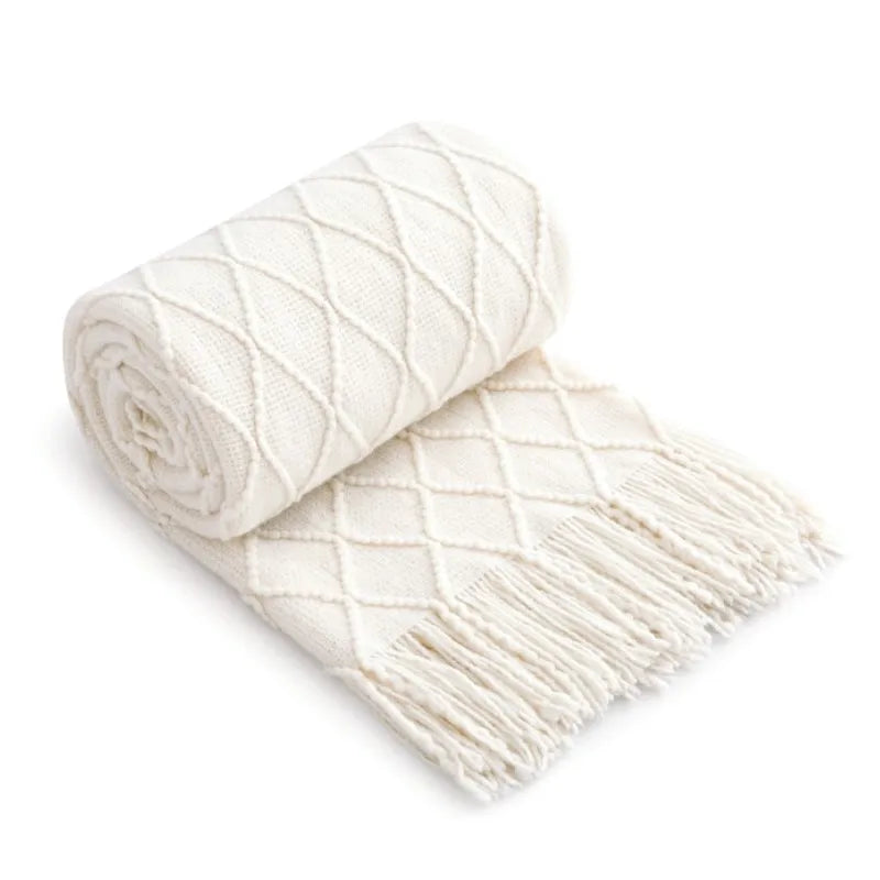 Plaid tricoté bohème blanc cassé Nesty - Roulé sur lui-même montrant motif losanges et longues franges