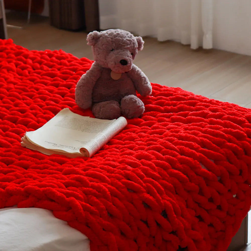 Plaid tout doux Nesty - Coloris rouge à grosses mailles, sur lit avec livre ouvert et peluche ours