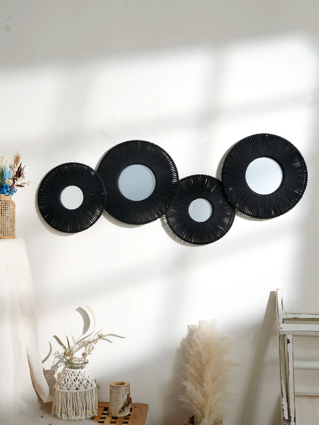 Ensemble de 4 miroirs muraux ronds en corde tressée façon soleil, coloris noir, avec vase en osier et fleurs séchées - Nesty