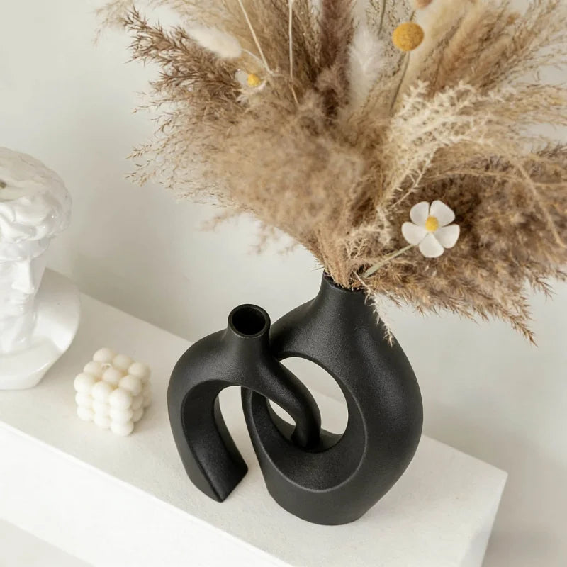 Set de vases imitation céramique Nesty - Modèle noir en gros plan avec pampa et marguerite, près d'un buste blanc