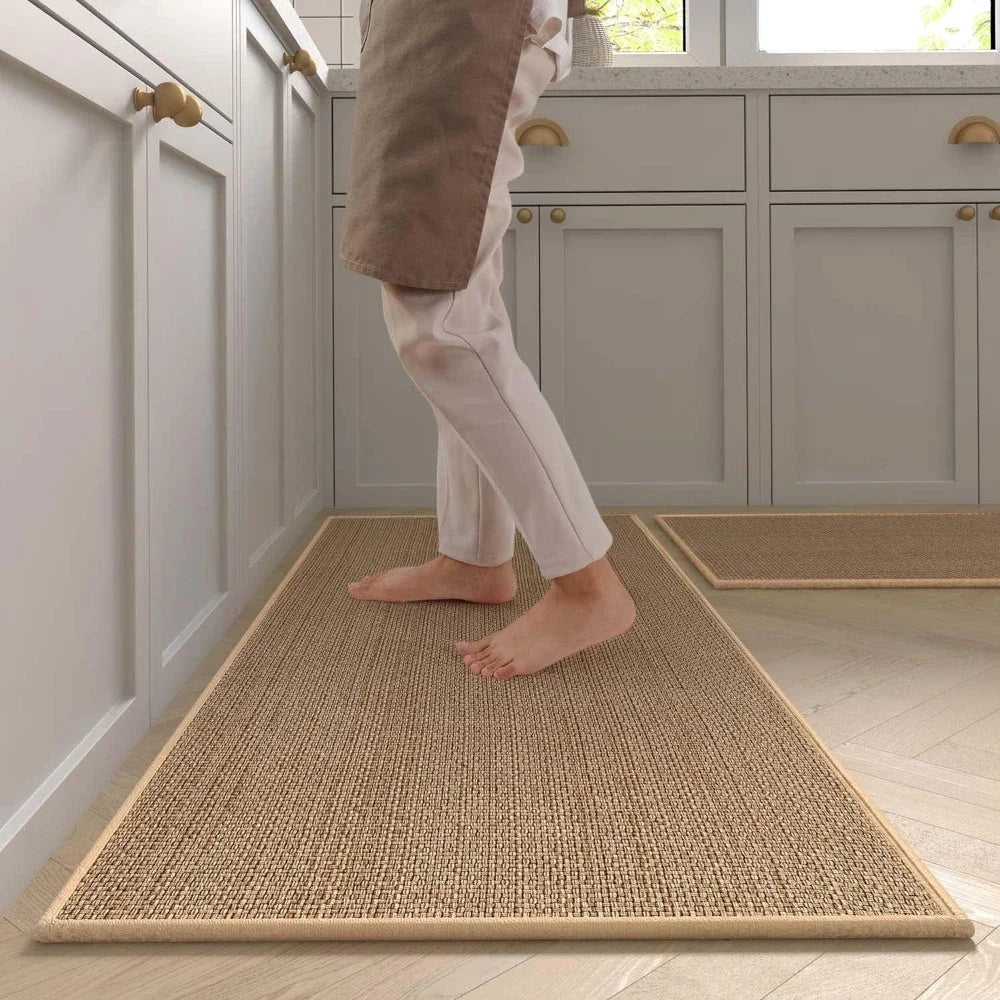 Tapis de cuisine imitation sisal — dos en caoutchouc naturel - Nesty, chemin de cuisine beige façon sisal, pieds nus posés dessus, autre tapis assorti en arrière-plan