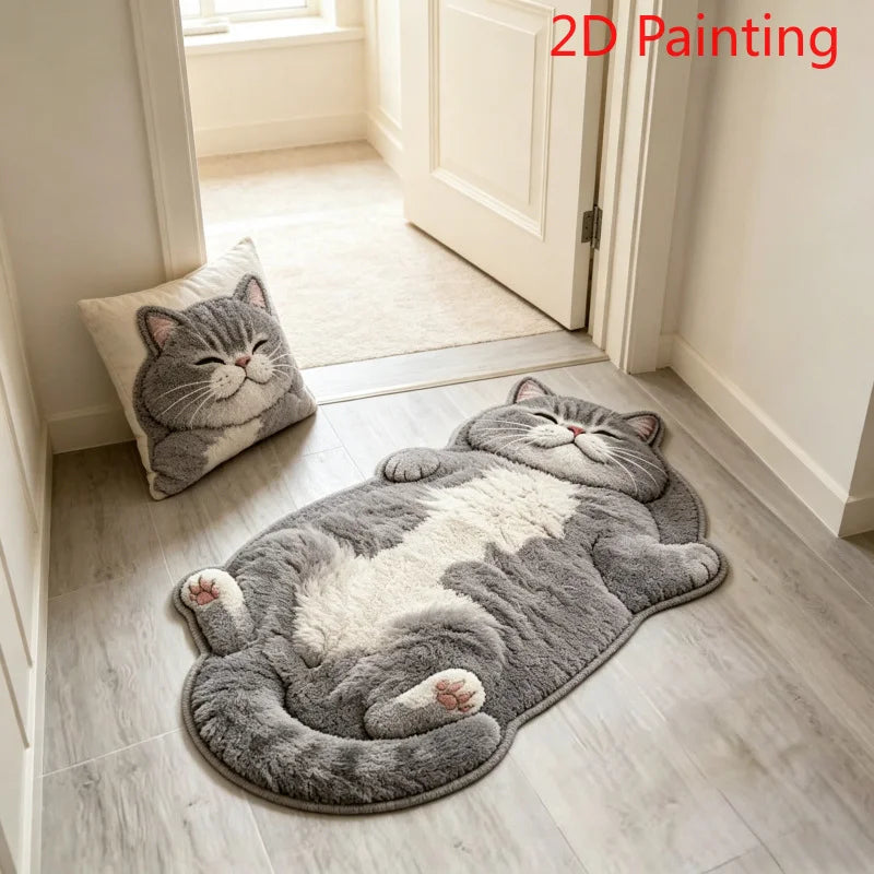 Tapis en forme de chat gris et blanc allongé, posé dans une entrée devant une porte, avec un coussin assorti en forme de tête de chat.