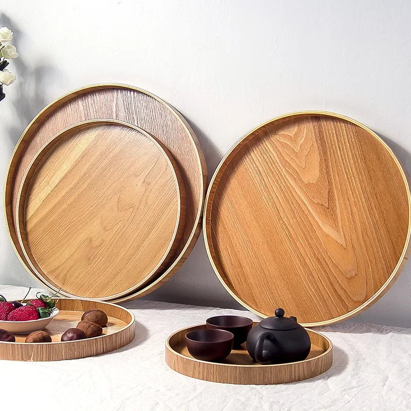 Plateau rond en bois à style japonais Nesty, plateaux vus de profil empilés en éventail, service à thé en arrière-plan