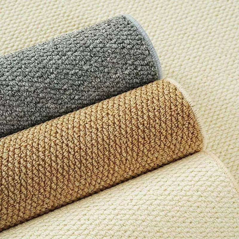 Trois rouleaux de tapis effet sisal tressé en coloris gris, beige et ivoire, gros plan sur le tissage - Nesty
