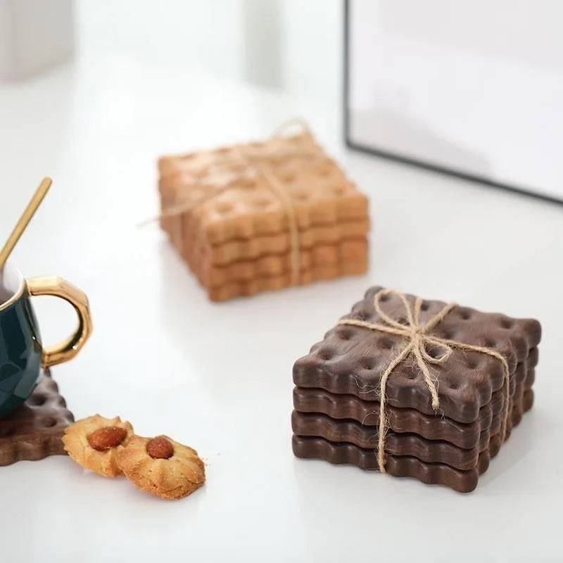 Piles de dessous de verre en bois forme biscuit, ficelées avec de la ficelle kraft, coloris clair et foncé, avec biscuits aux amandes - Nesty