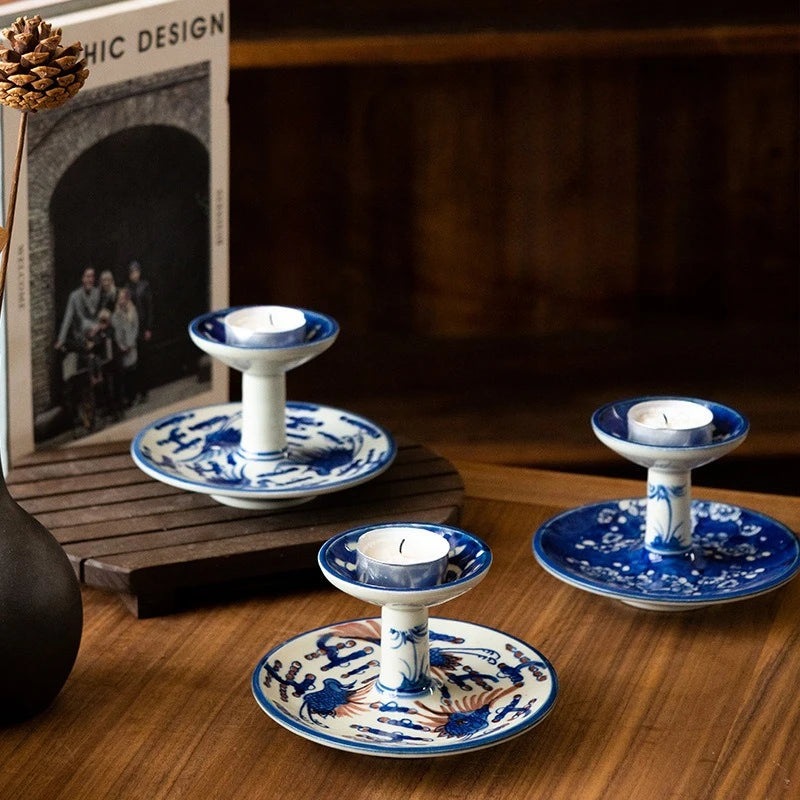 Trois bougeoirs en porcelaine peinte à la main bleu et blanc motif oiseaux et fleurs, avec bougies chauffe-plat, sur table en bois - Nesty