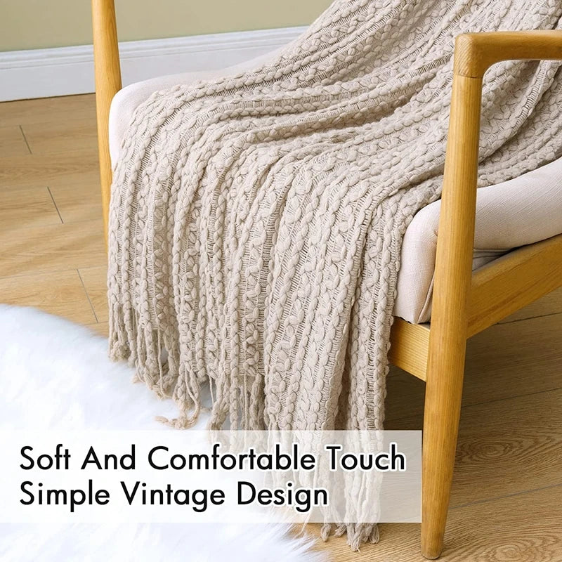 Grand plaid bohème tricoté Nesty - Drapé sur fauteuil en bois vintage, franges tombées au sol