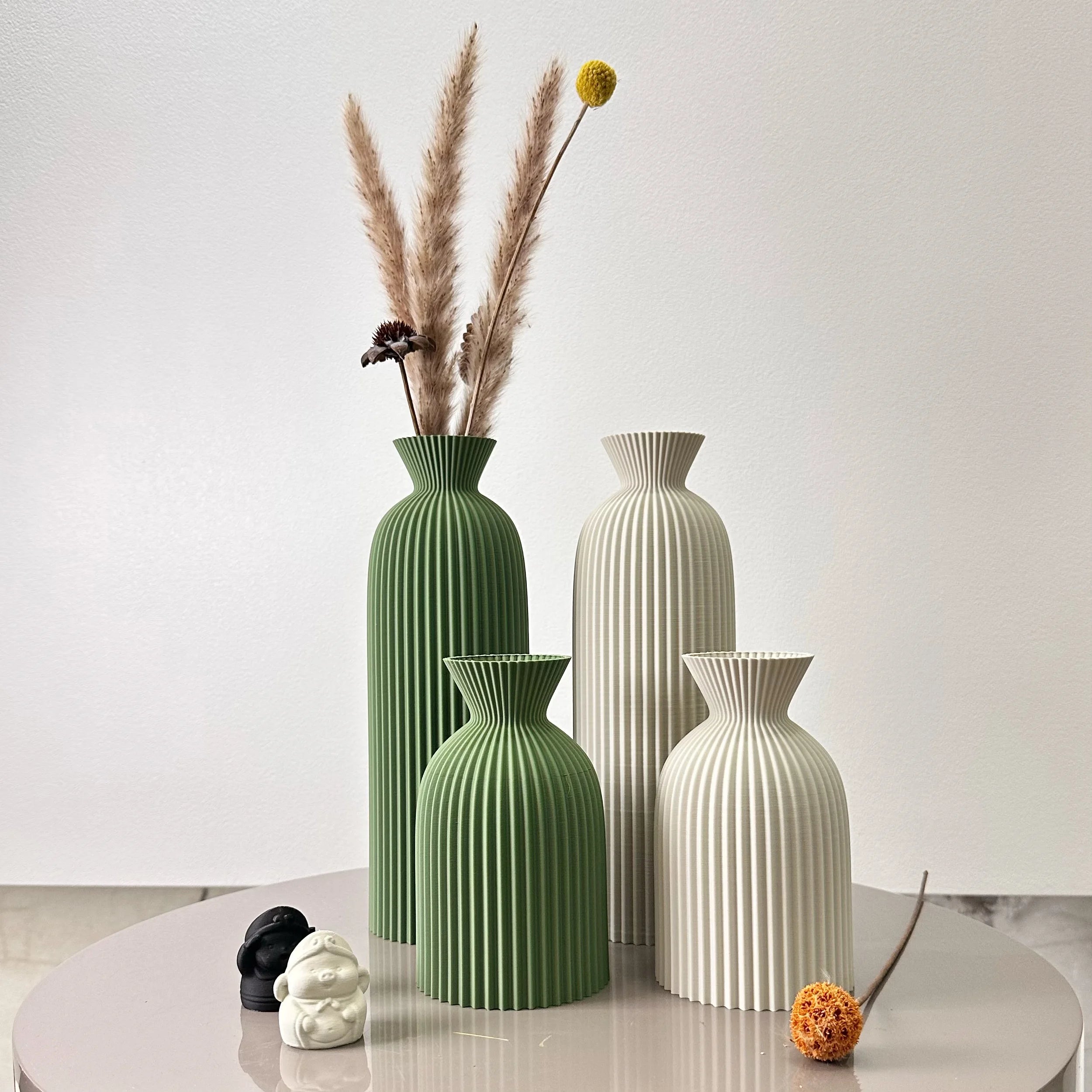 Duo de vases à motif ondulé pour fleurs séchées Nesty, quatre vases côtelés en vert et blanc, le plus grand vert garni d'herbes de pampa et d'une fleur jaune