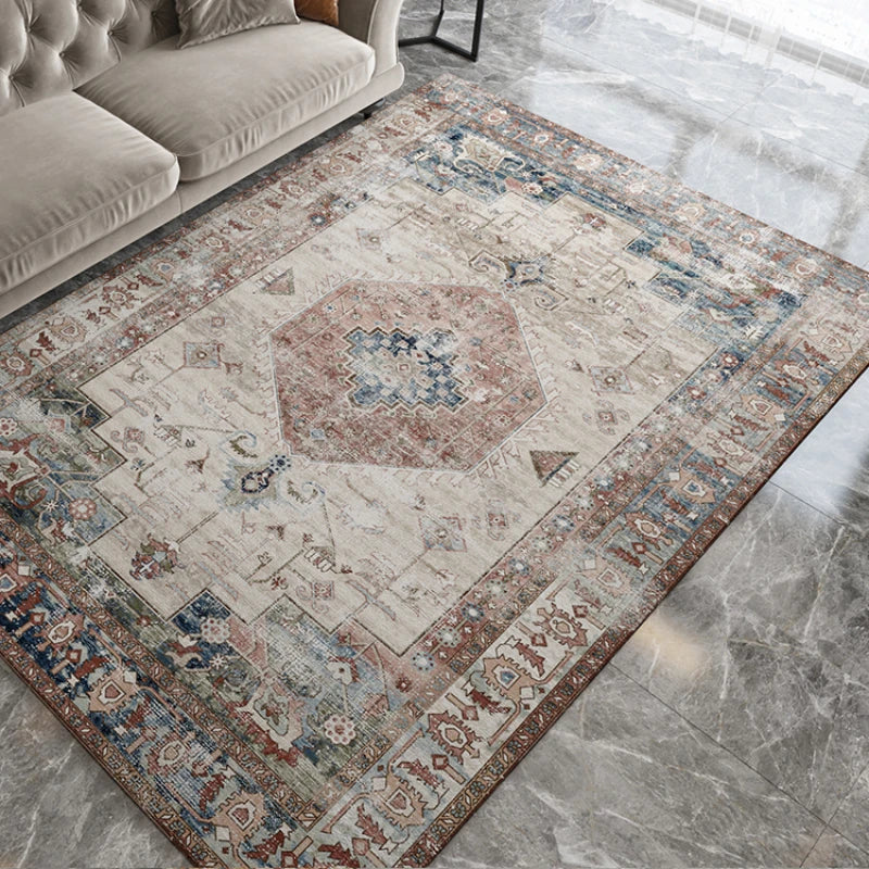 Tapis à motif géométrique rétro pour salon Nesty - Motif médaillon ethnique beige, bleu et terracotta sur sol en marbre