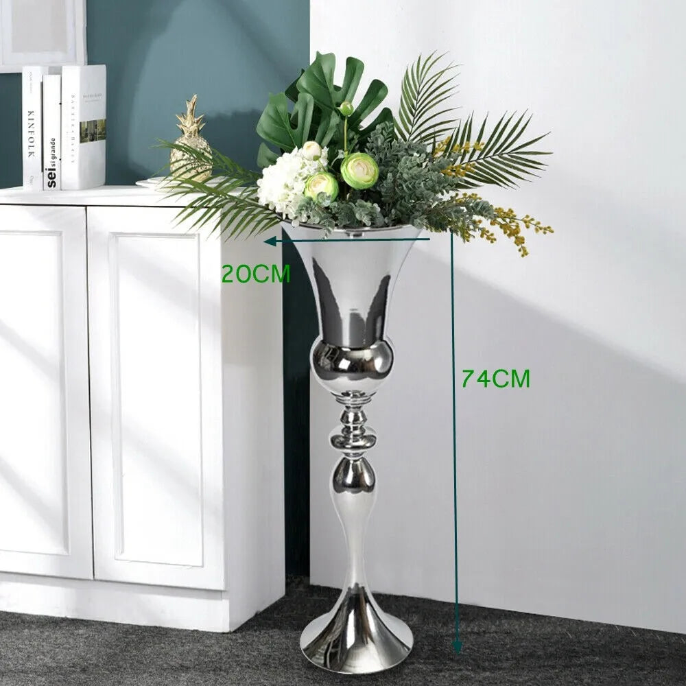Vase en métal finition dorée, design élégant - Nesty - Grand vase sur pied en métal argenté finition miroir, garni de feuilles tropicales et fleurs blanches, avec cotations 20cm de diamètre et 74cm de hauteur
