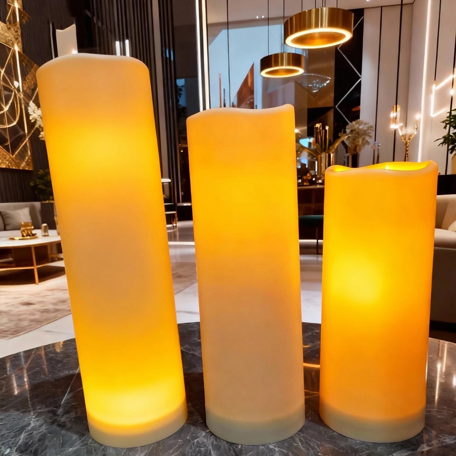 Bougies LED pilier vacillantes, télécommande, intérieur et extérieur Nesty, trois bougies LED pilier dans un salon lumineux avec suspensions dorées et canapé beige