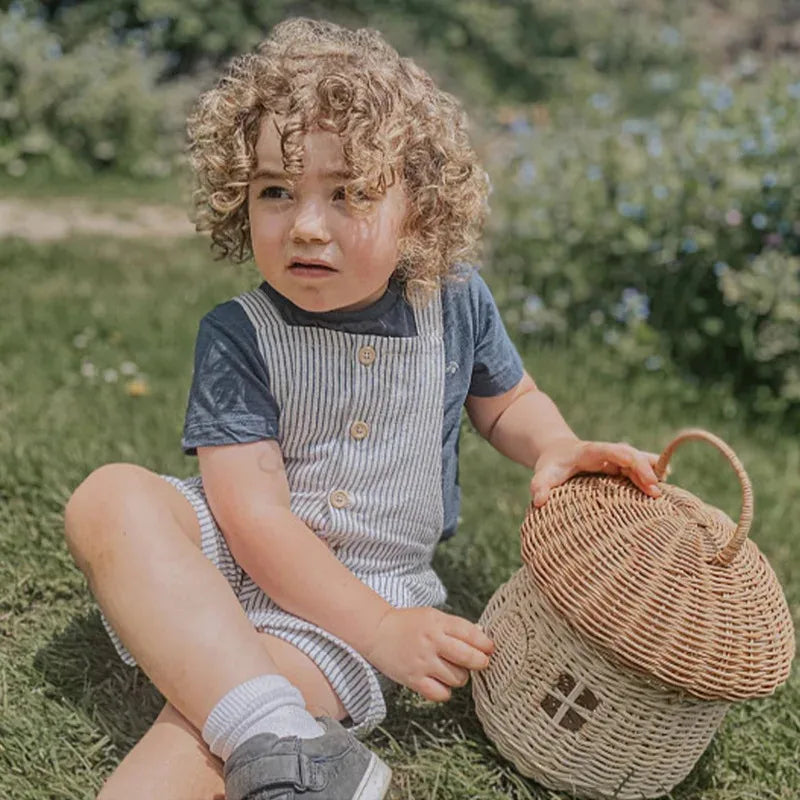 Panier tressé en bambou forme champignon Nesty - Tenu par un enfant assis dans l'herbe