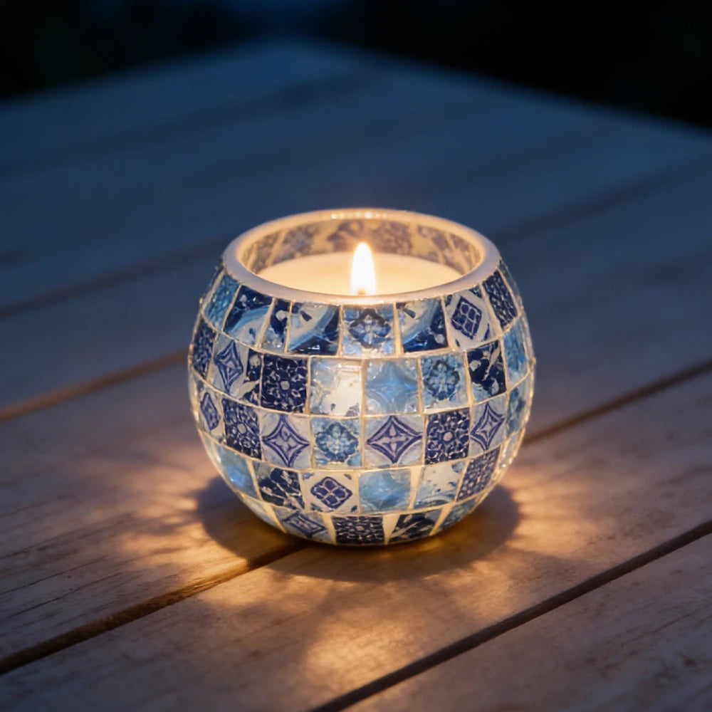 Photophore en verre mosaïque bleu et blanc façon carreaux de faïence, bougie allumée sur une terrasse en bois le soir - Nesty