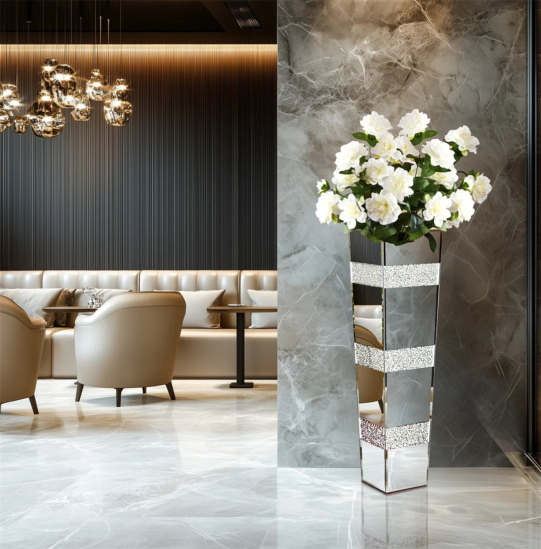 Vase sol en verre et cristal, finition miroir argentée - Nesty - Grand format avec bouquet de roses blanches artificielles, dans un intérieur en marbre gris avec fauteuils beiges