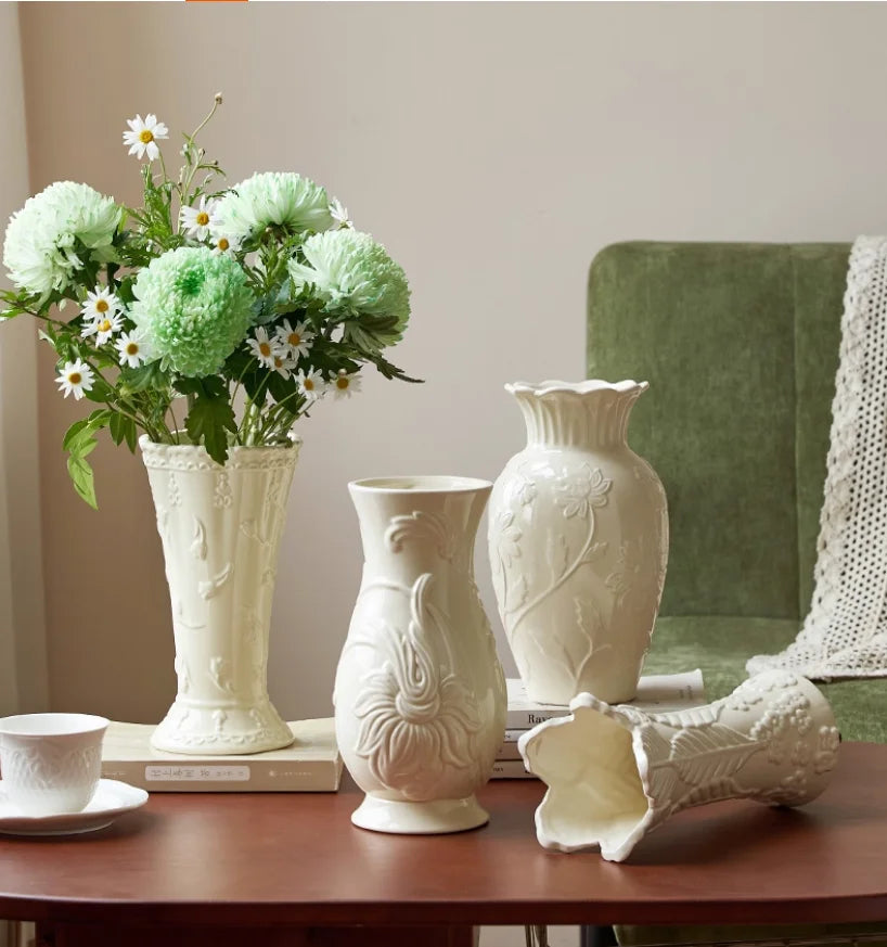 Vase en céramique crème à relief, style intemporel Nesty, quatre vases à relief floral de tailles et formes différentes, l'un garni de fleurs vertes et blanches