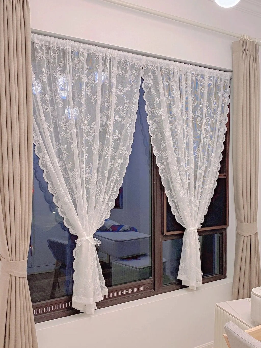 Voilage à motif dentelle florale Nesty - Deux panneaux blancs noués installés sur une fenêtre de chambre