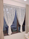 Voilage à motif dentelle florale Nesty - Deux panneaux blancs noués installés sur une fenêtre de chambre