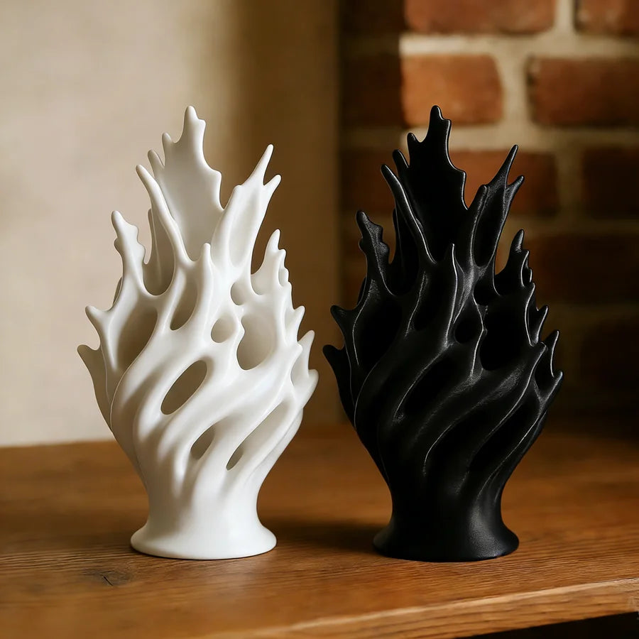Vase en plastique léger, format table à manger Nesty, gros plan sur les deux formes ajourées en flamme, blanche et noire, sur table en bois